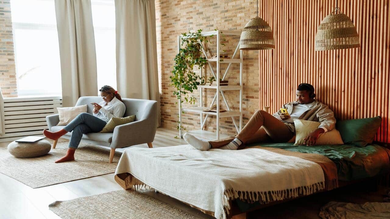 A couple using their phones in the bedroom