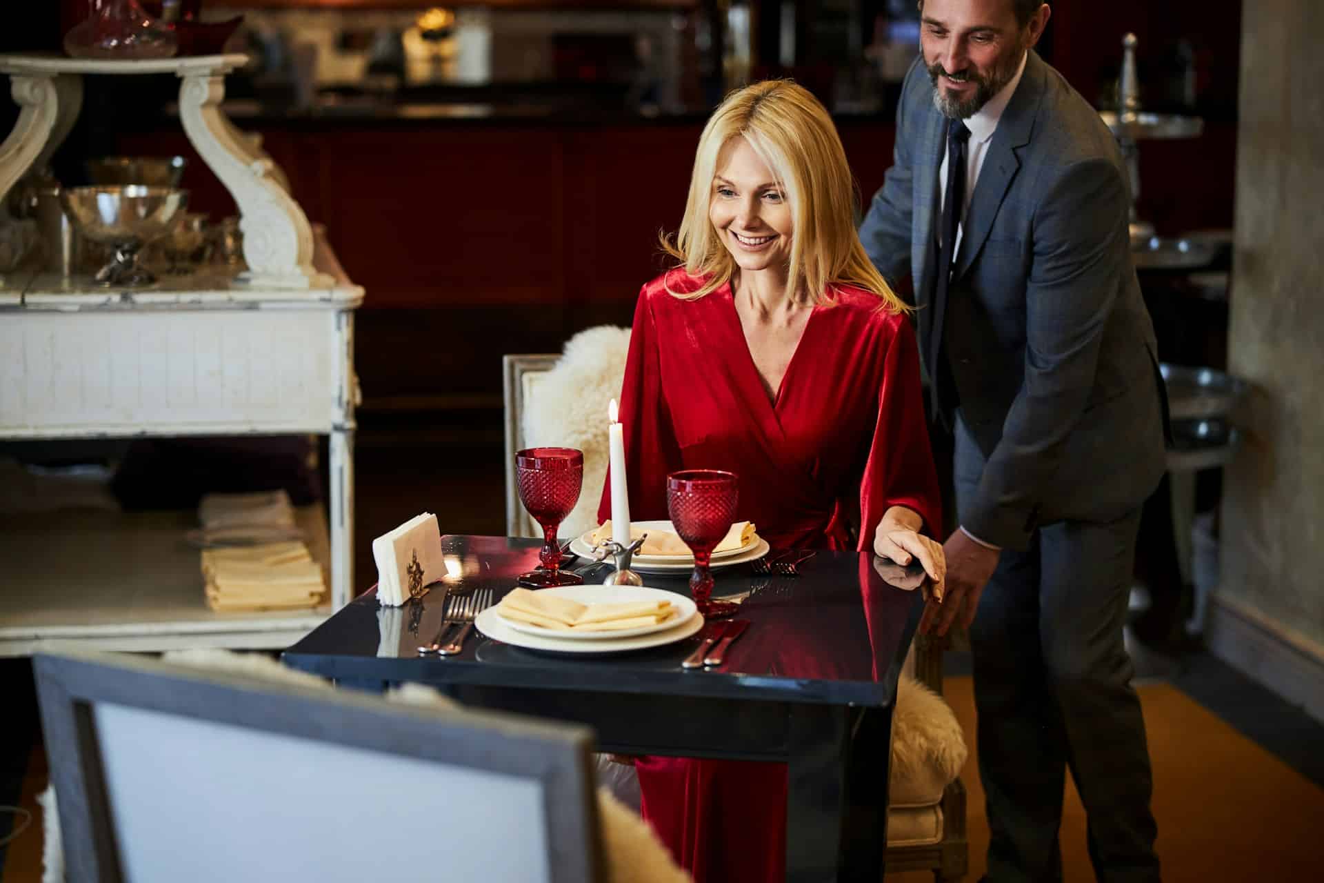 A well-mannered man on a date with a woman wearing a red dress