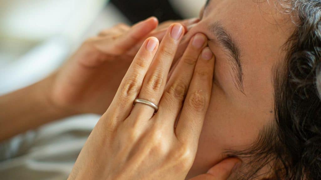 A person covering their face with their hands.
