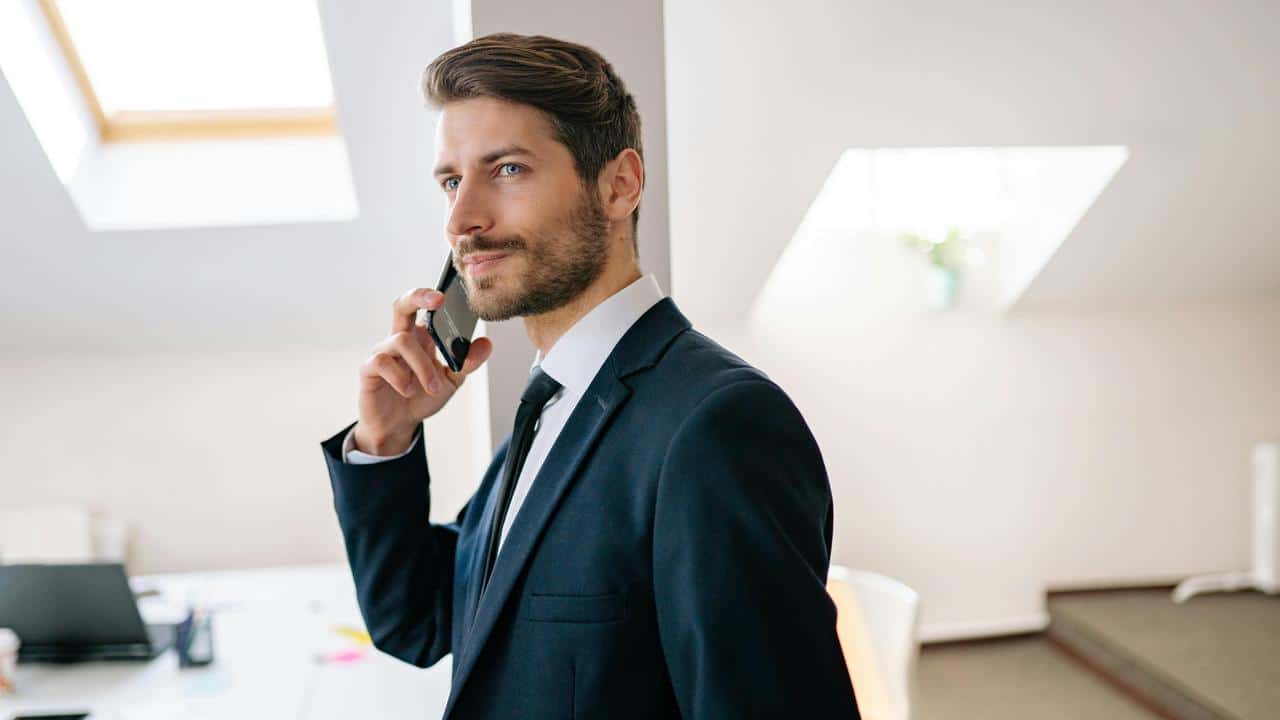 A man in a suit talking on a phone.