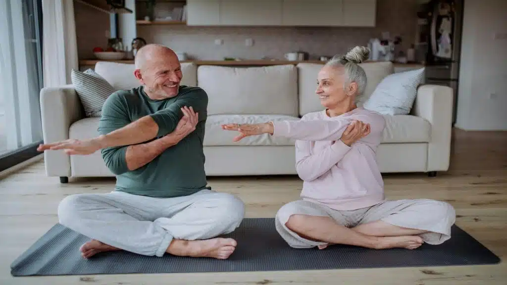 A senior couple stretching at home