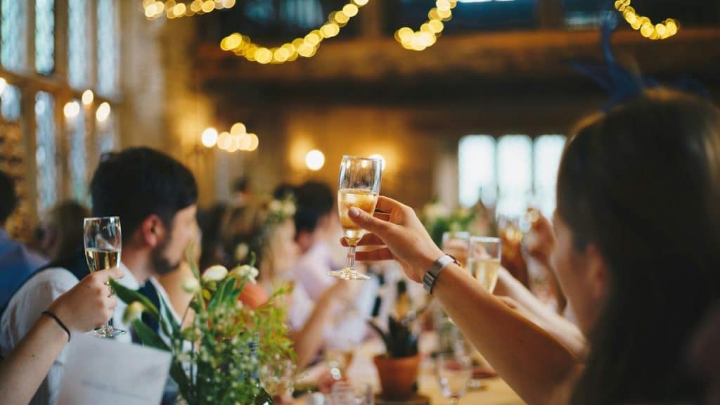 A group of people raising glasses in a warmly lit celebration.