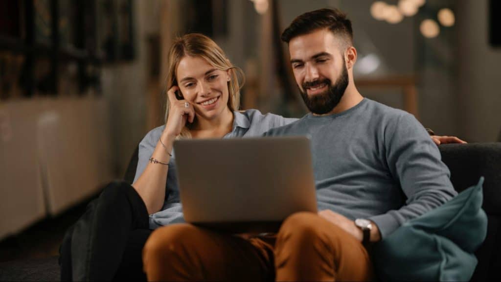 A man and woman looking at the laptop