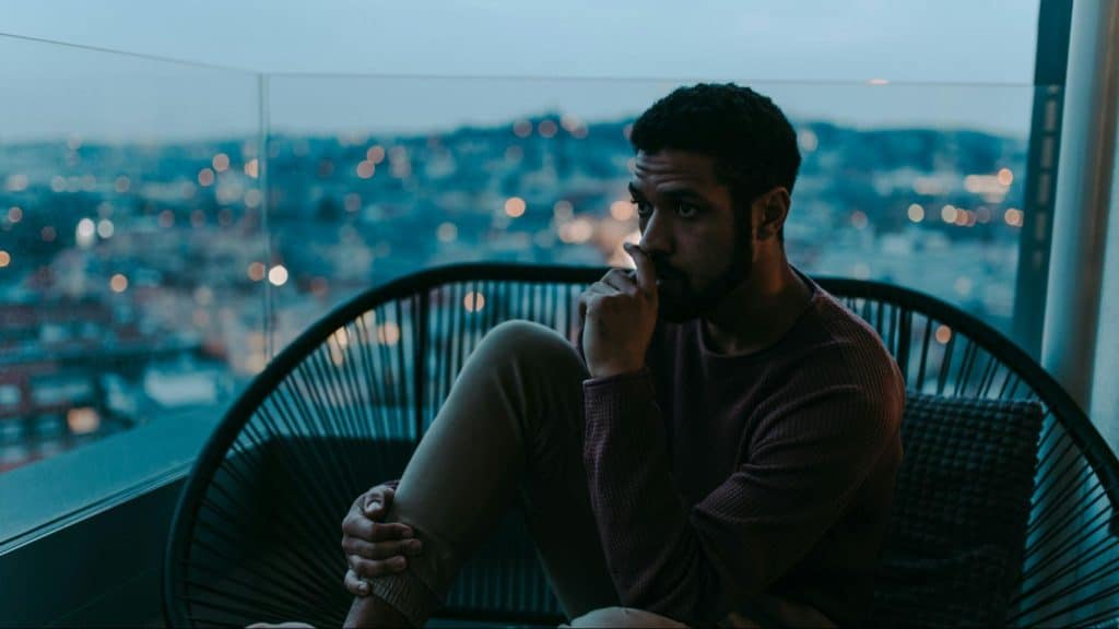 A man thinking beside the big window