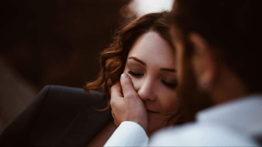 A man holding woman’s face