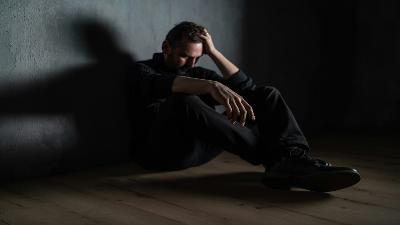 A man crying on the floor