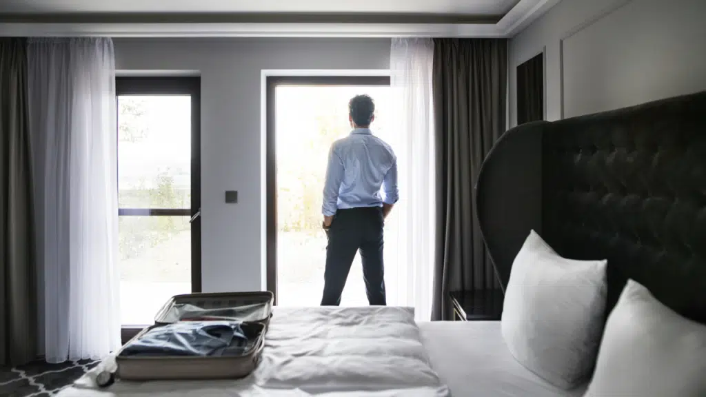 A man looking out the window of a hotel