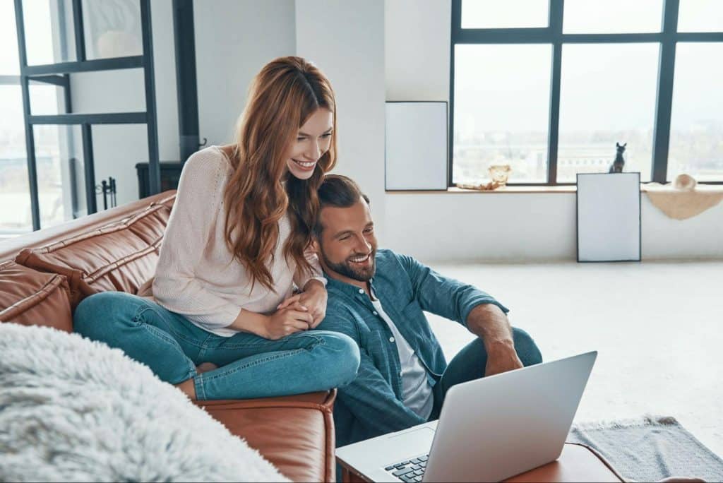 A man and woman looking at the laptop 
