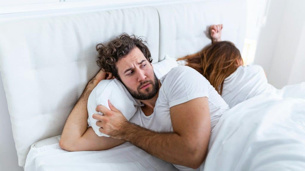 A couple lying on a bed after a fight.