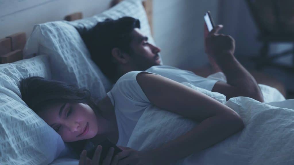 A couple using their phones late at night