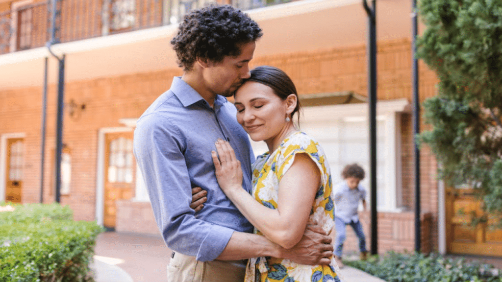A man giving his wife a forehead kiss