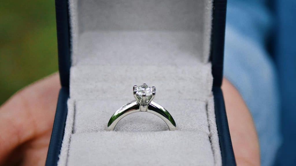 An engagement ring displayed in an open jewelry box.