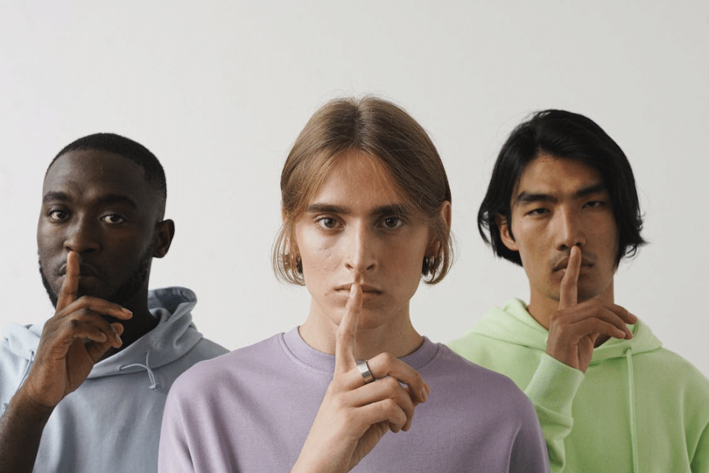 3 men doing the silence sign