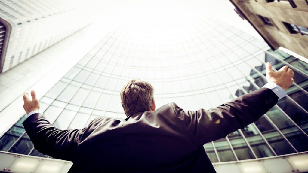 A man wearing a suit in the middle of buildings.