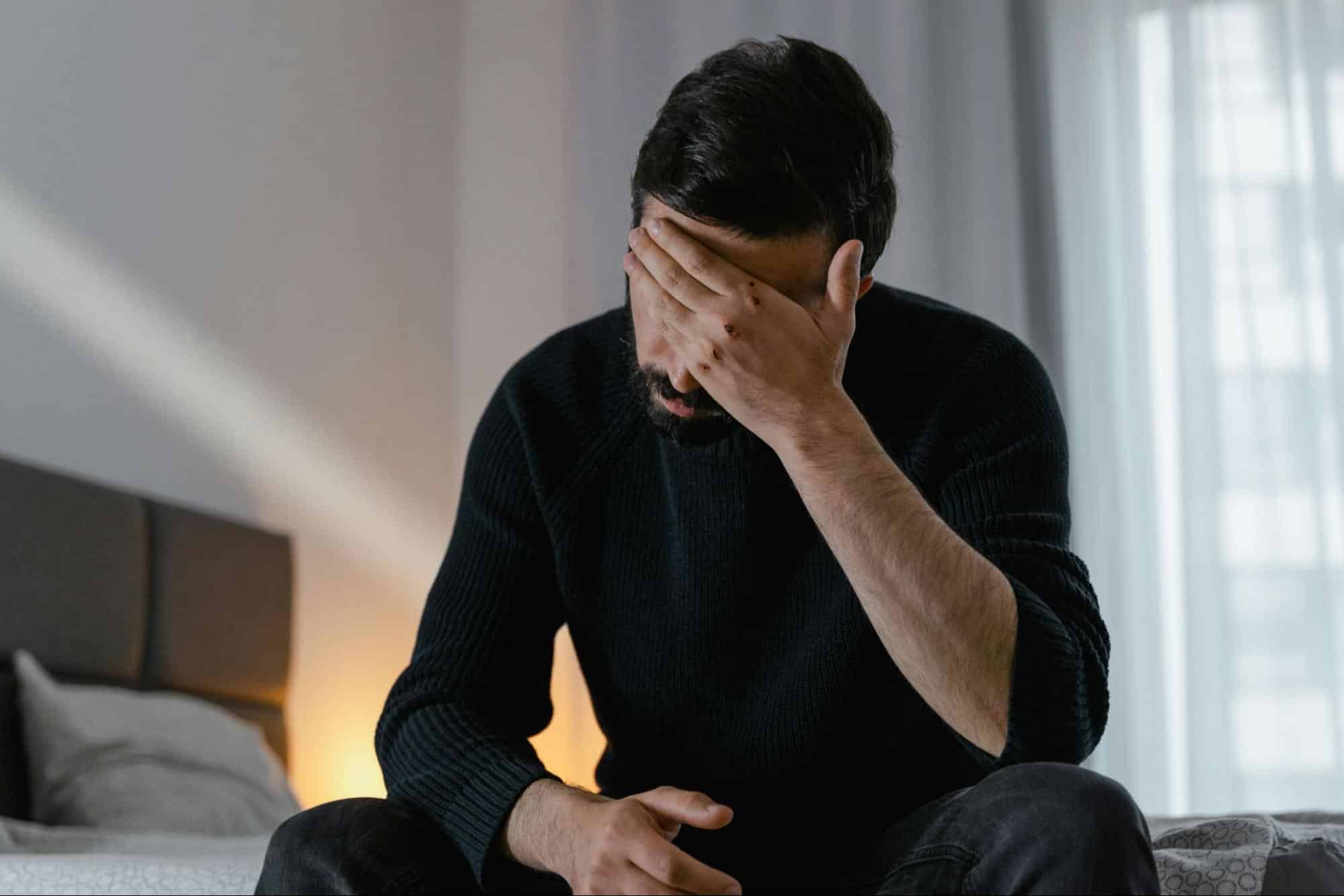 A man covering his eyes
