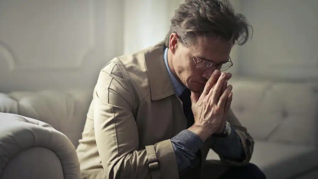 A man sitting on a couch at home alone.