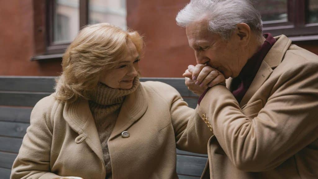 A man kissing his wifeβs hand