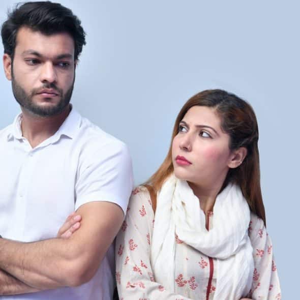 A man and a woman standing back to back.