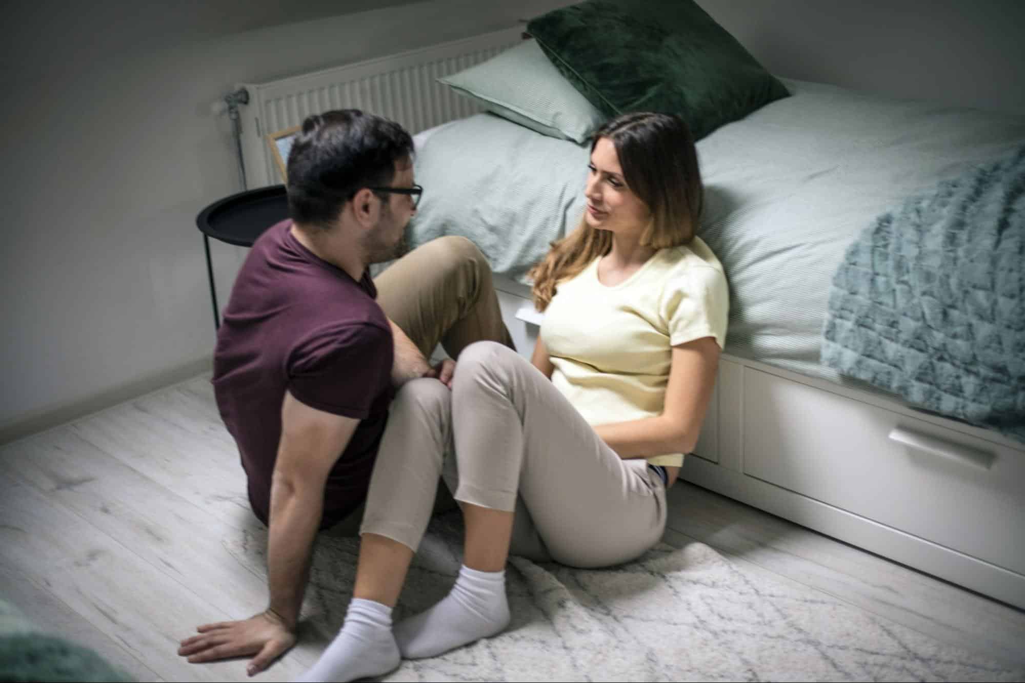 A man and woman talking while on the floor