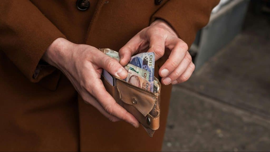 A man holding a wallet with money inside