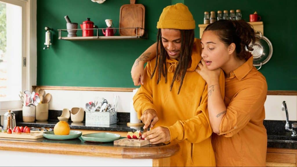 A woman being close while a man prepare a food