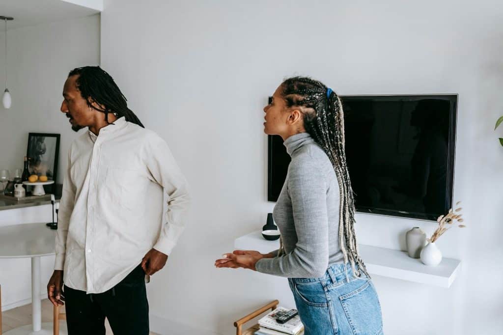 A woman looking confused as her partner looks away from her mid-conversation.