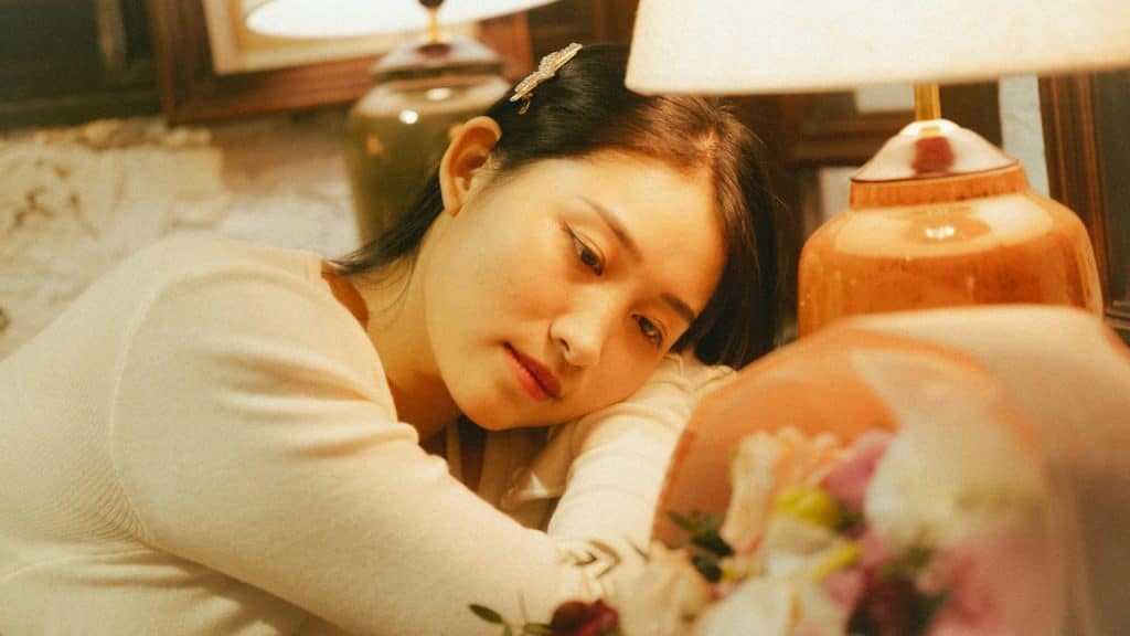 A thoughtful woman lying on the couch.