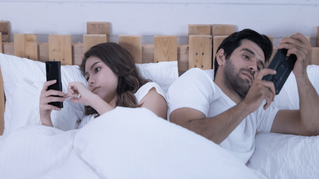A couple using their phones at home