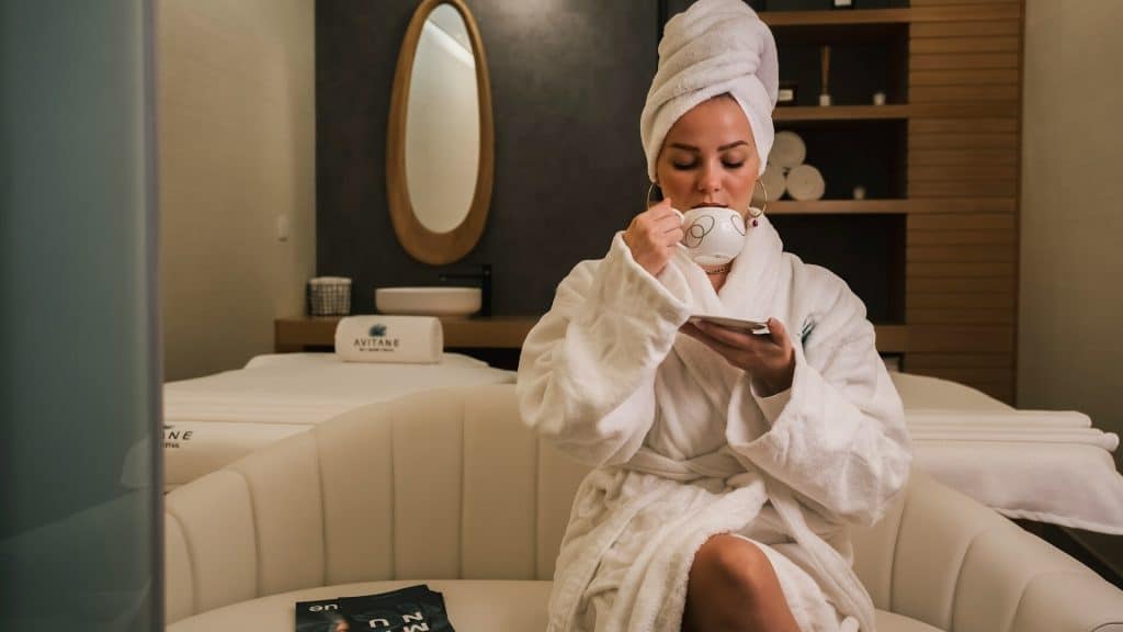 A woman in a white robe sitting on the couch.