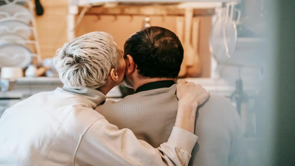 A woman kissing her husband on the cheek