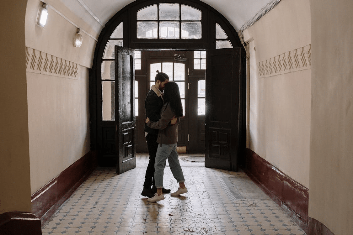 A couple hugging in the hallway