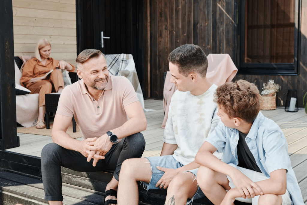 Father and two sons sitting on a step