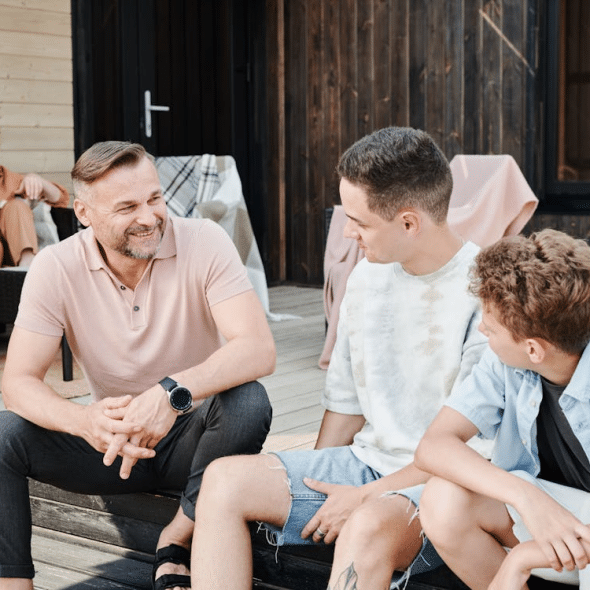 Father and two sons sitting on a step
