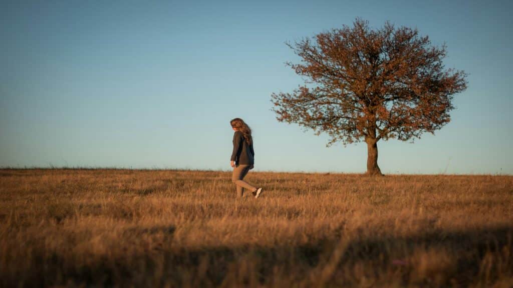 A woman walking sadly in a field