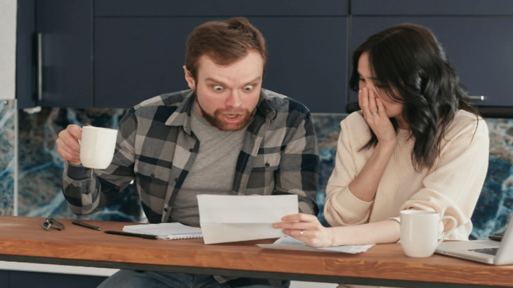 A couple looking shocked at the bills