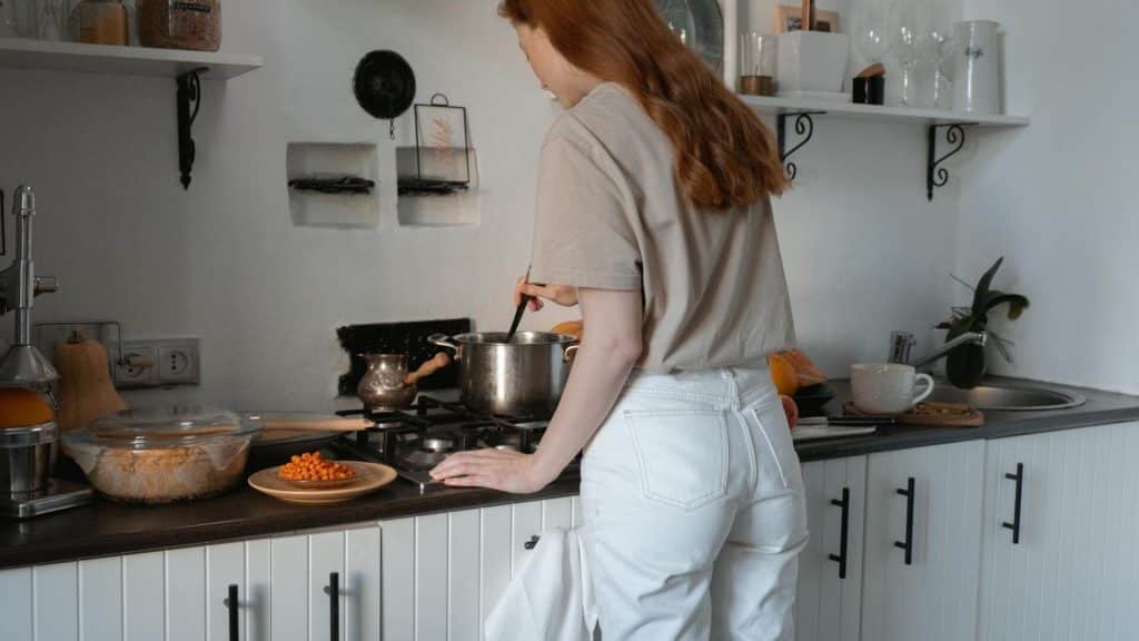 A woman cooking alone in the kitchen.