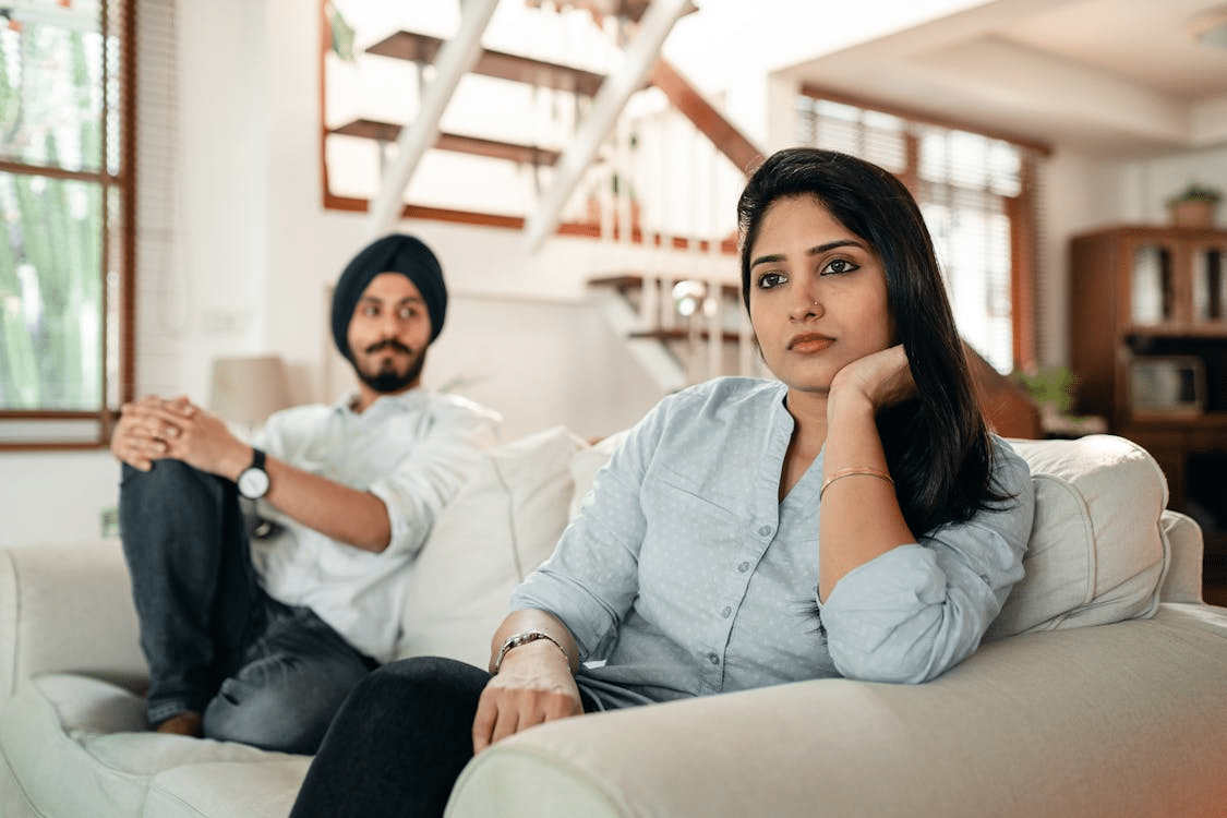 Offended female sitting on couch with husband
