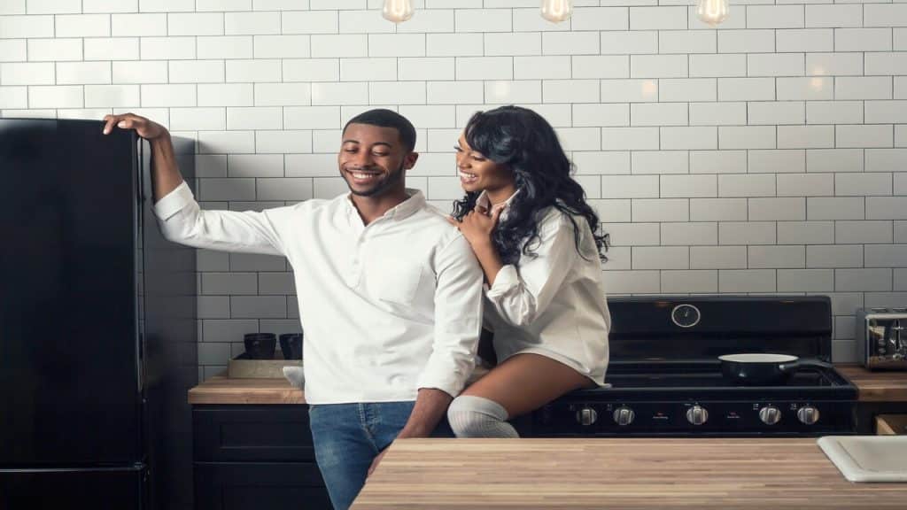 A couple laughing in the kitchen