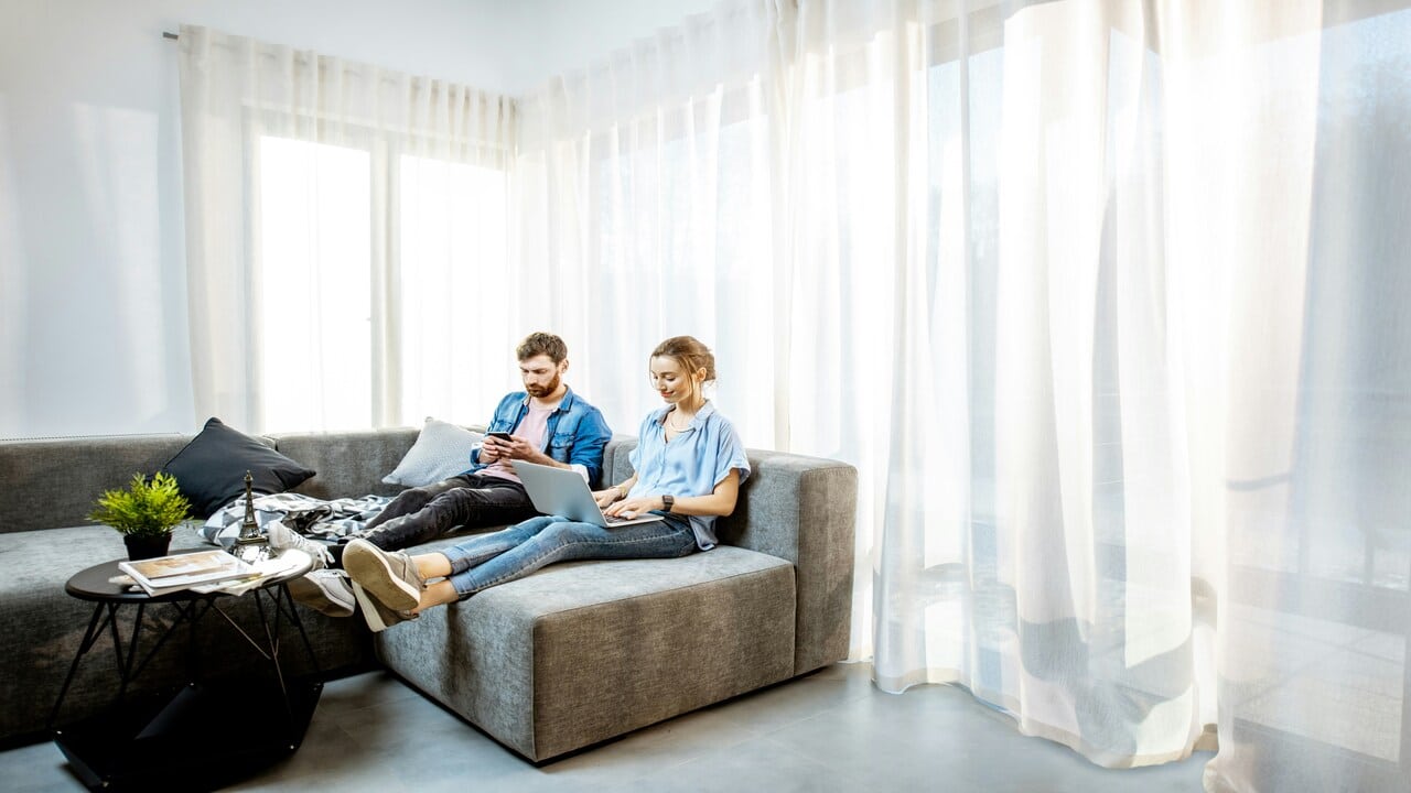 A couple using their devices at home