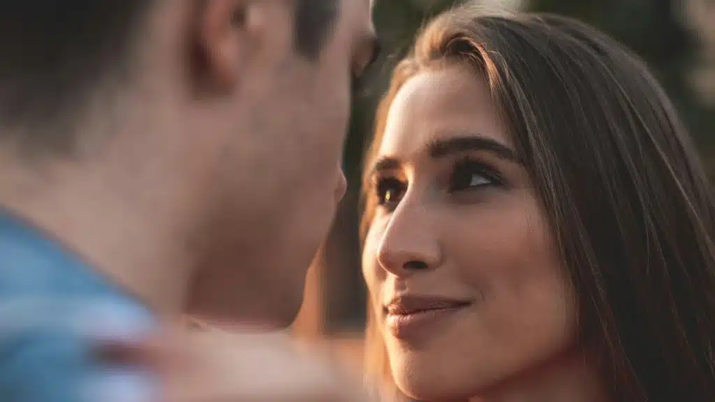 A woman smiling and staring in a man’s eyes.