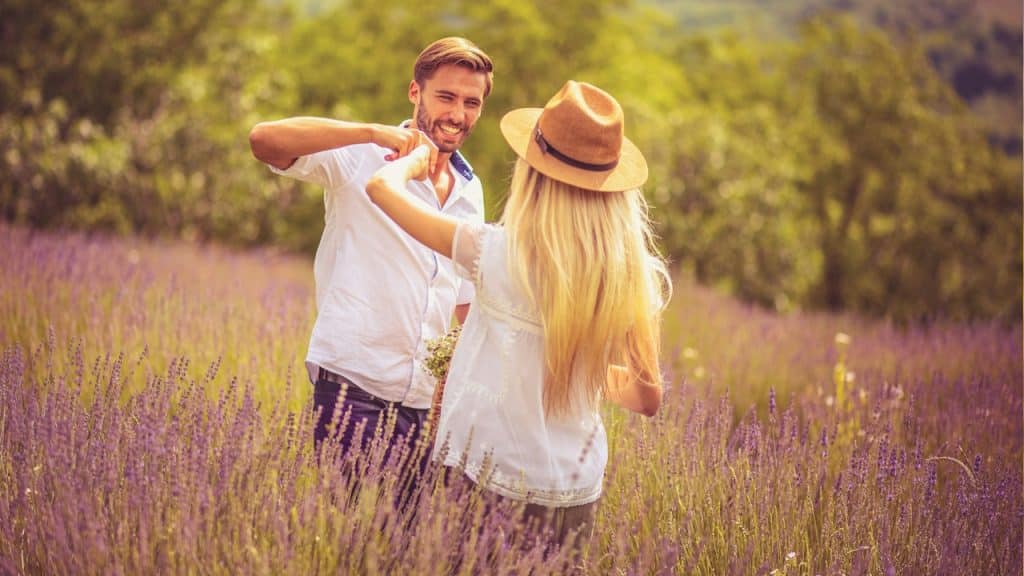 A man and a woman standing in a lavender field.