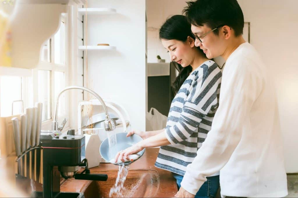 A man and woman washing dishes
