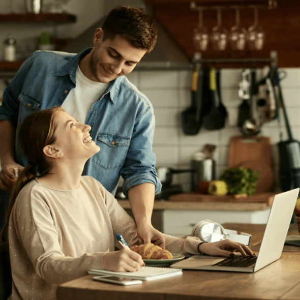 A man feeding his wife while she works