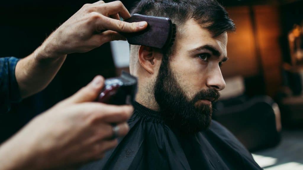 A man getting a haircut with electric clippers.