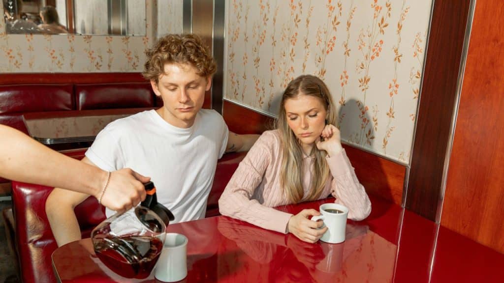 A man and a woman having coffee together in a restaurant.