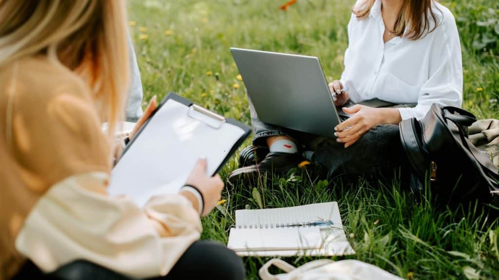 Two people working on laptops and completing some assignments.