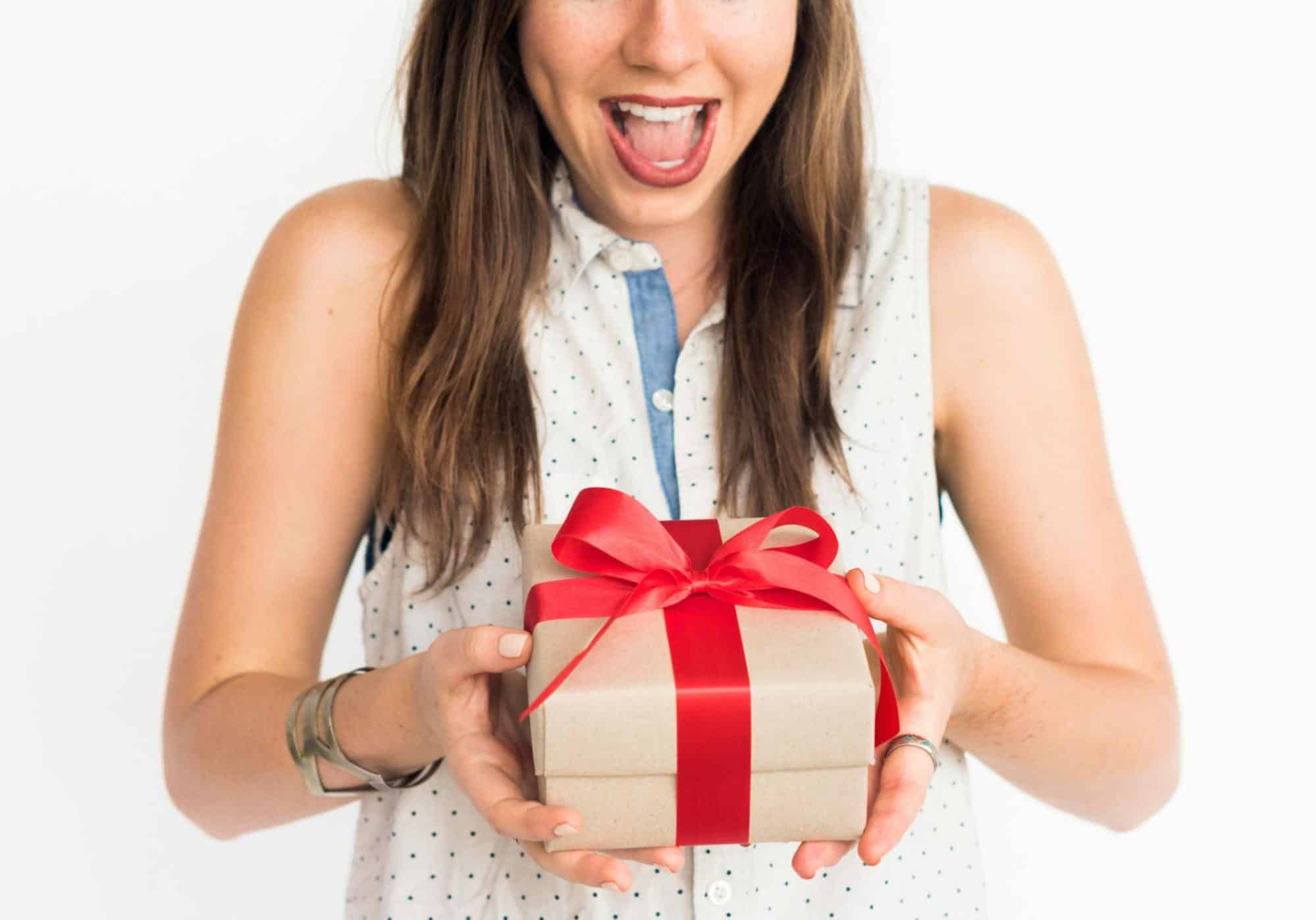 A woman holding a box with just a ribbon