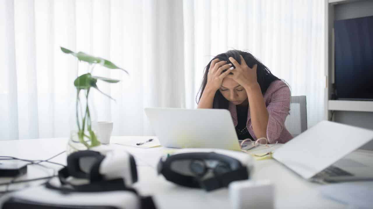 A woman looking stressed in front of the laptop