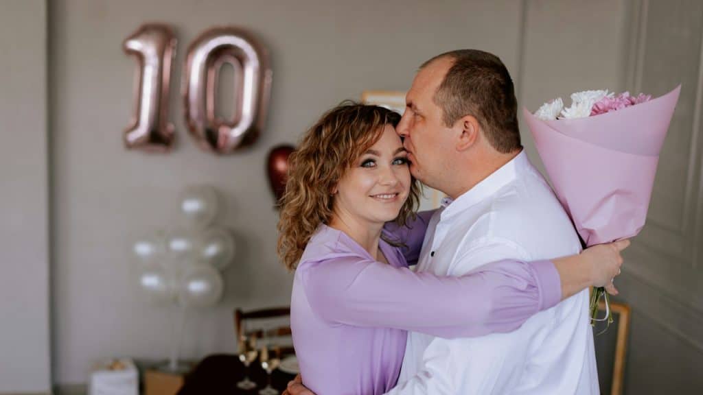 A man and a woman embracing each other at their 10th wedding anniversary.