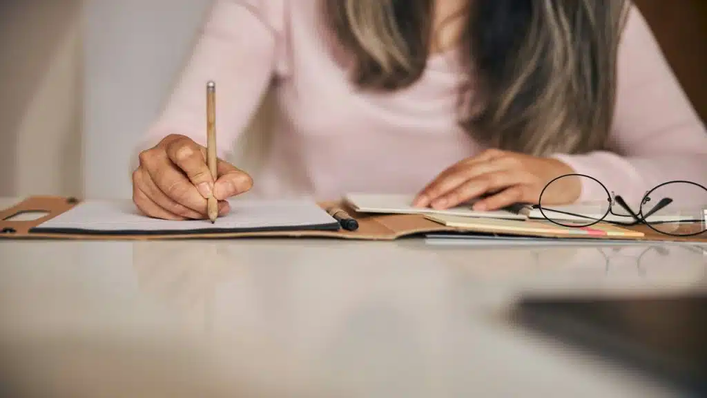A woman writing on a planner
